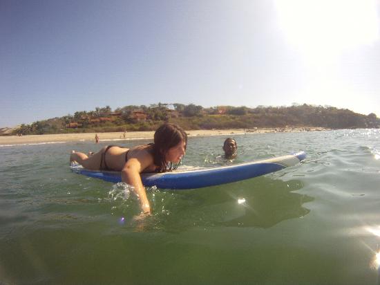 girl paddling during surf lesson in puerto escondido